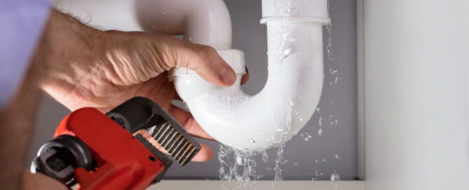 plumber fixing a leaky pipe
